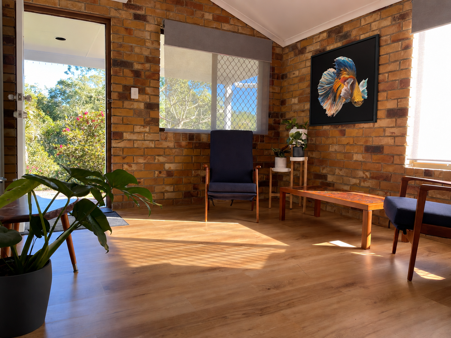The clinic’s sunlit lounge with garden views, plants and fish artwork